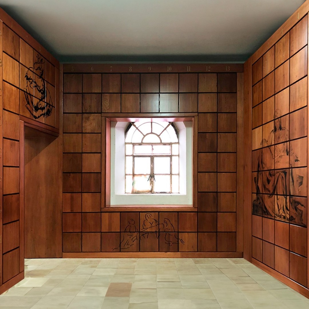 Espacio de nichos con revestimiento de madera, decorado con grabados religiosos y una ventana arqueada, creando un ambiente cálido y solemne